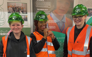 Three students wearing hard hats