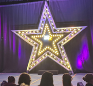 A large star on a stage for a performance by Capa College